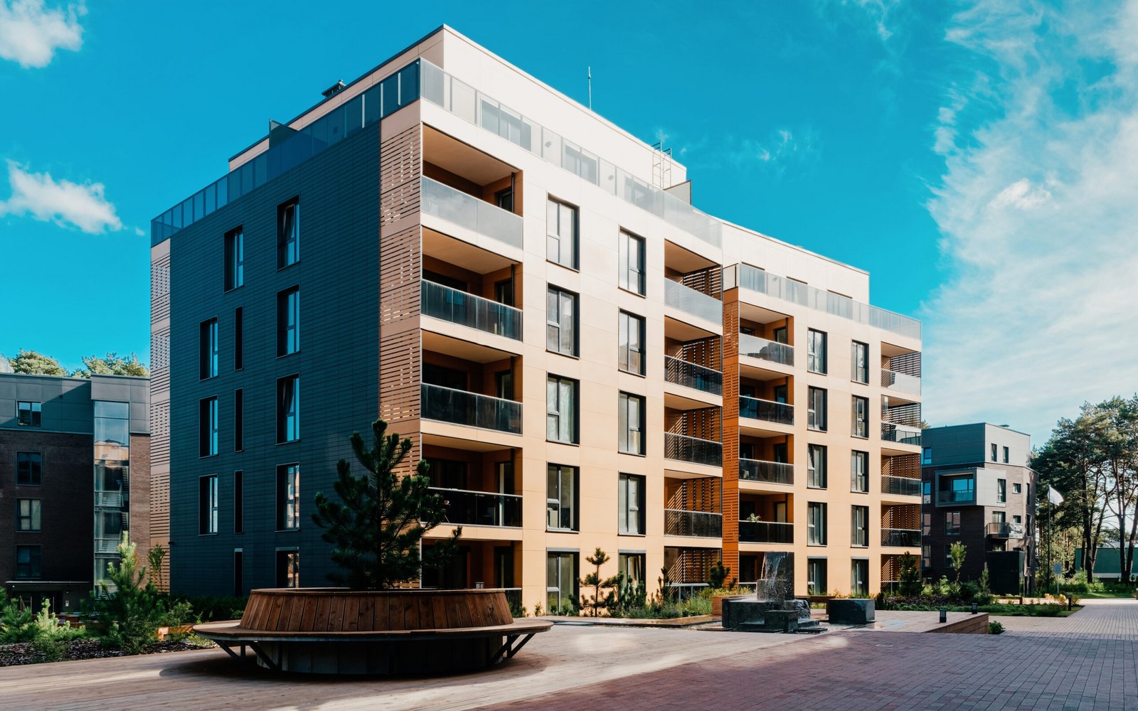 A modern multi-story apartment community with balconies and a landscaped courtyard